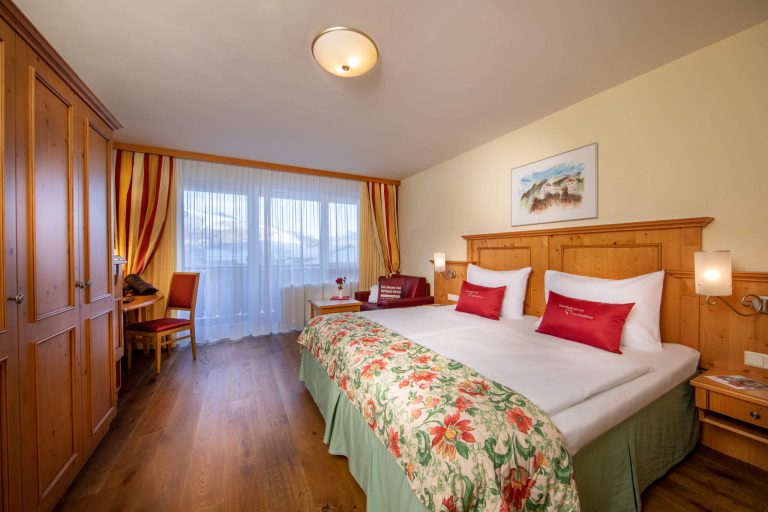 Gemütliches Zimmer im 4-Sterne Vötter's Hotel mit Bergblick und warmem Holzdekor.