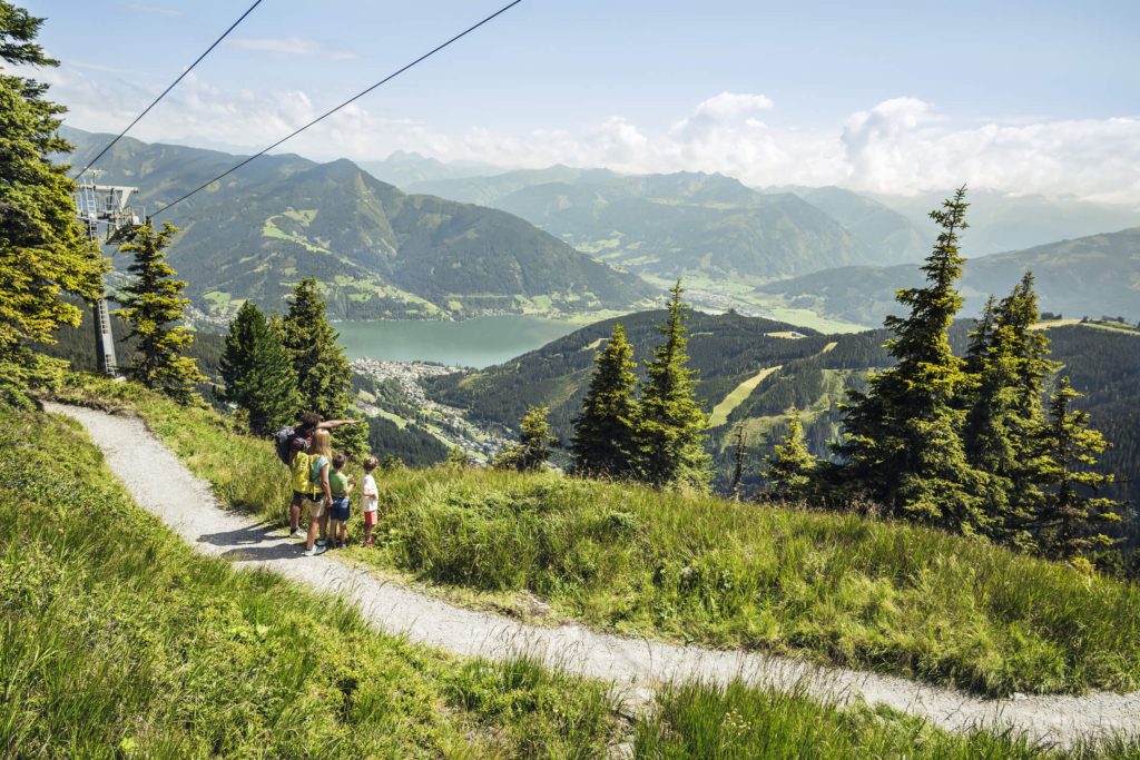 Familie wandert auf einem Pfad mit Blick auf den Zeller See und die Berge in Kaprun.