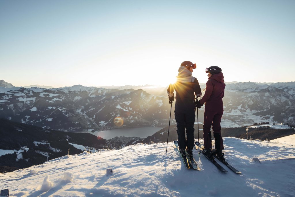 Paar im Skianzug genießt den Sonnenuntergang über den Alpen in Kaprun.